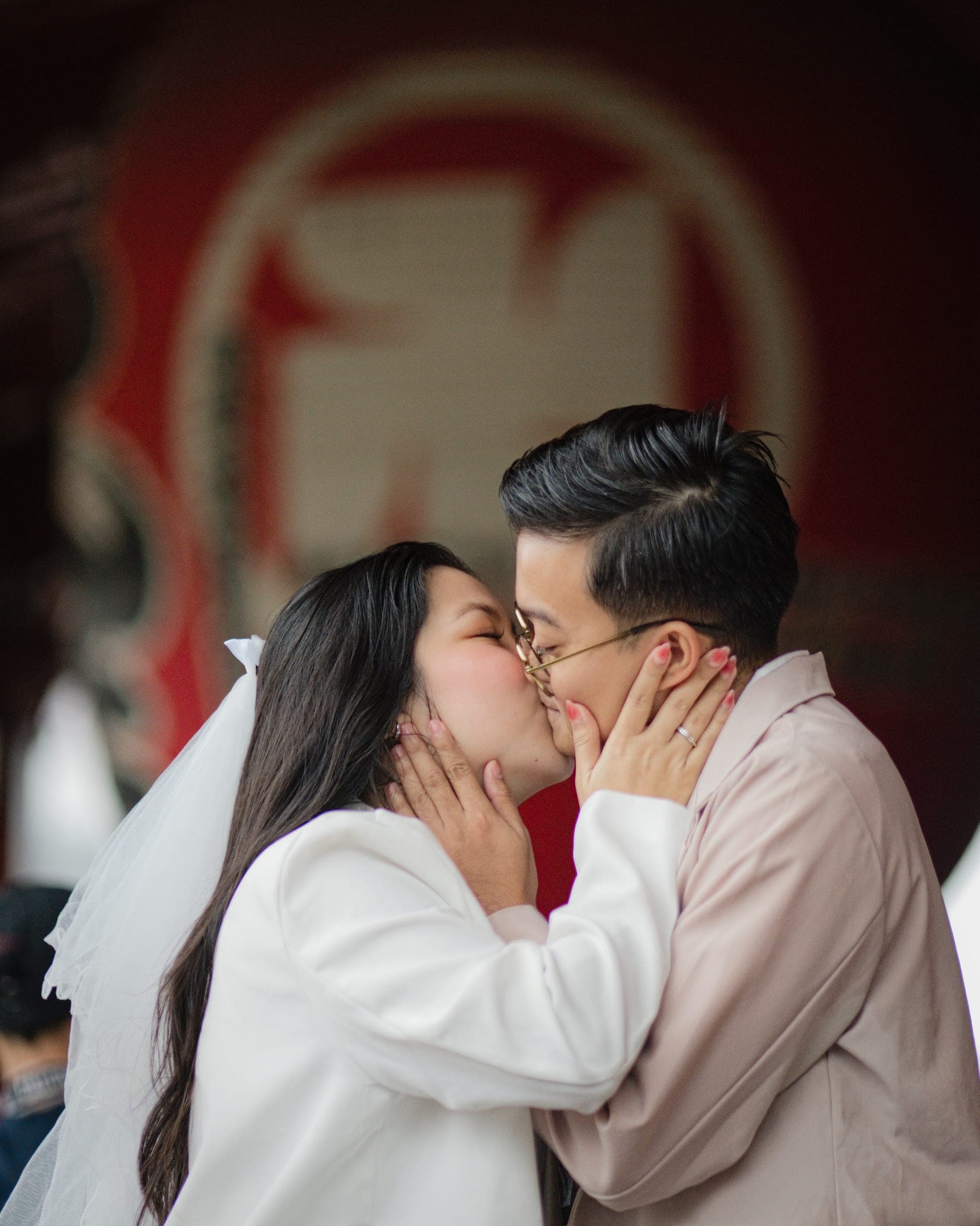 A newly engaged couple kissing beneath a temple lantern